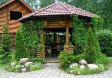 ביתן גן צריך להיות משולב בסגנון עם בית כפרי, עם זאת, אתה יכול להסוות אותו בזהירות עם צמחים