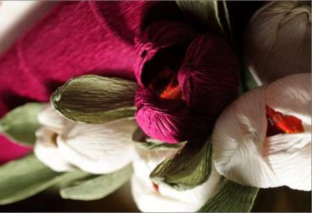 Verwenden Sie Klebeband, um die Blütenblätter am Stiel zu befestigen. Fertig ist eine Blume aus Süßigkeiten und Wellpappe.
