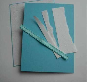 Ze silného tyrkysového papíru uřízněte obdélník 14 × 18 cm. Tento papír složte rovnoměrně na polovinu. Poté z bílého papíru vystřihněte menší obdélník - 13 × 17 cm. Oboustrannou páskou slepte tyto dva listy papíru k sobě. Poté opatrně ořízněte okraje tyrkysového papíru tak, aby nevyčnívaly více než 0,5 cm.