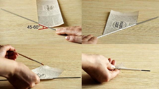 Begynn å vikle avisstrimler på et spyd, og slik at røret ikke bretter seg, smør spissen med lim