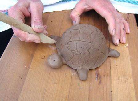 Vergessen Sie nicht, einen Stapel zu verwenden, um die Textur des Schildkrötenpanzers zu zeichnen, damit das Handwerk in Miniatur alle Merkmale dieses Tieres widerspiegelt. Sie können einen Panamahut oder einen Rock für Ihre Figur nähen, alles hängt von Ihrer Vorstellungskraft ab und