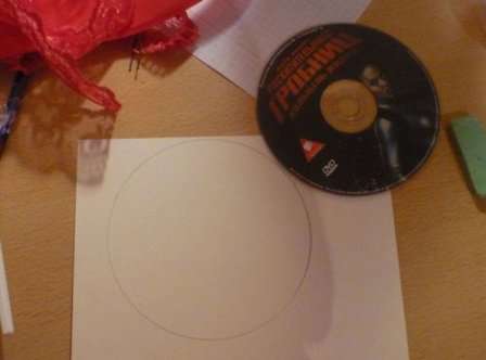 Nimm einen Kompass oder eine alte CD und zeichne sie mit einem Bleistift auf den Karton, du solltest einen Kreis bekommen. Danach müssen Sie vorsichtig